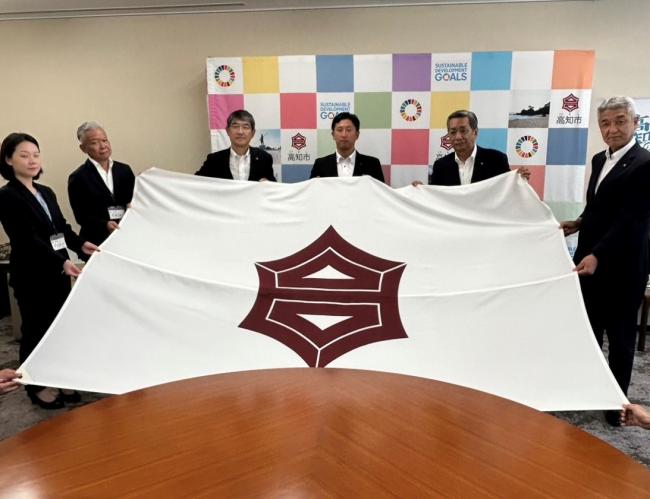 高知市関係者と四国銀行野球部様が高知市旗を持った集合写真