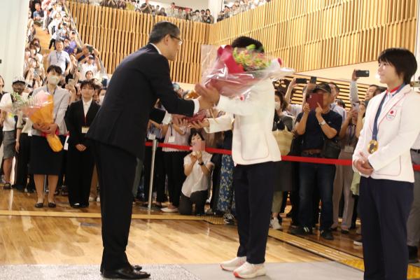 市長が清岡選手に花束を贈っています